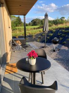 a patio with a table and chairs and an umbrella at Tiny House Ô Secret du Wérihay in Spa +23 photos