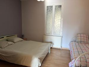 a bedroom with a bed and a window at La Parenthèse in Sagy