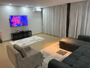 a living room with two couches and a tv at Studio B Luxury - Waterfront in Dakar