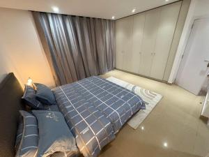 a bedroom with a bed and a large window at Studio B Luxury - Waterfront in Dakar