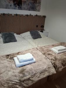 two beds with towels sitting on top of them at L Ecrin des Cimes 6 voyageurs in Arâches-la-Frasse