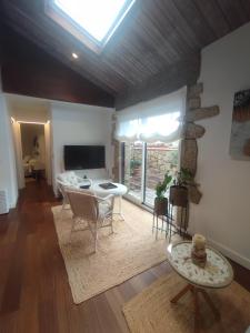 a living room with a table and a fireplace at O Iniño casita rural costera in O Grove +25 photos