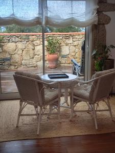a table and two chairs with a laptop on it at O Iniño casita rural costera in O Grove