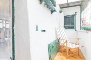 a wooden chair sitting on a porch with a window at Levanto lodge in Levanto