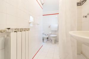 a white bathroom with a toilet and a sink at Levanto lodge in Levanto