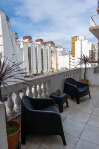 a balcony with two chairs and a table and buildings at Hotel Miami in Mar del Plata