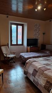 a bedroom with two beds and a flat screen tv at La dimora del lago in Meina +27 photos