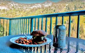 a table with a plate of food and a can of soda at Condo Right on the Snowbird Slopes! in Sandy