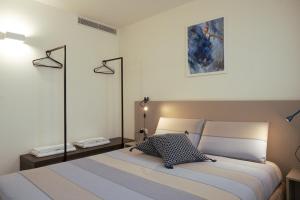 ein Schlafzimmer mit einem Bett und zwei Wandlampen in der Unterkunft Residenza SubitoSanto "Gigliola" 9A - Bilocale con terrazzo esclusivo Cupola Basilica di Sant'Antonio- in Padua