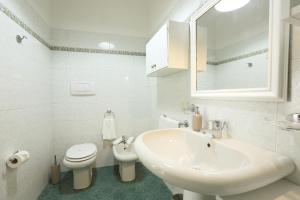 a white bathroom with a sink and a toilet at La Valletta - Casa di Anna in Menaggio +51 photos