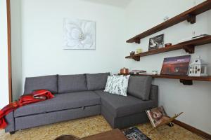 a living room with a gray couch and a shelf at La Valletta - Casa di Anna in Menaggio