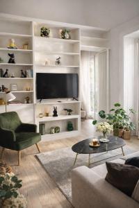 a living room with a flat screen tv on a white shelf at Maison Opéra in Palermo
