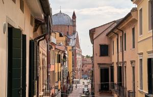 eine Stadtstraße mit Gebäuden und einem Uhrturm in der Unterkunft Residenza SubitoSanto "Gigliola" 9A - Bilocale con terrazzo esclusivo Cupola Basilica di Sant'Antonio- in Padua
