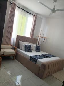a large bed in a room with a window at Ardina Studio in Mtwapa