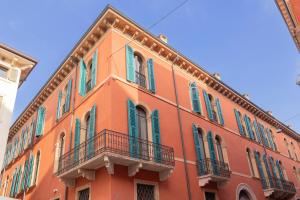 an orange building with green shutters on it at Palazzo Trezza in Verona