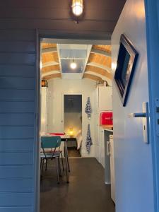 a small kitchen with a table and chairs in a room at Pipowagen in Haaksbergen