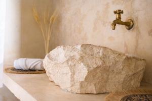 a bathroom with a rock on a counter with a faucet at Suite Privada Origen 63 Centro Histórico Mérida in Mérida