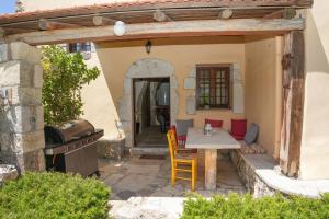 an outdoor patio with a table and a grill at Traditional Villa with pool in Sfakia in Ímbros