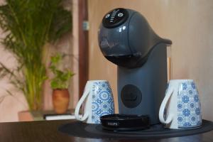 a hair dryer sitting on a table with two cups at Suite Privada Origen 63 Centro Histórico Mérida in Mérida