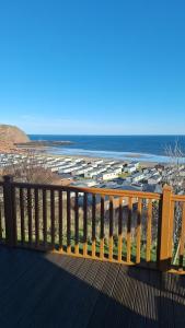 a wooden deck with a view of the beach at Bayview Luxury Lodge in Cockburnspath