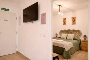a bedroom with a bed and a flat screen tv at Arenas del Coliseo Centro Parking Gratis in Mérida