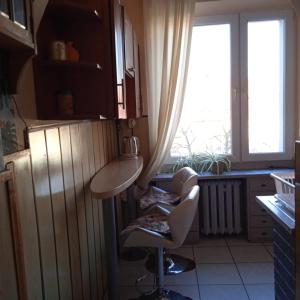a kitchen with a table and two chairs and a window at Gościnne Gniazdo in Będzin +1 photo