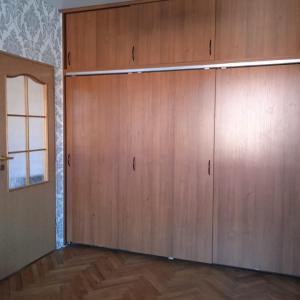 a large closet with wooden doors in a room at Gościnne Gniazdo in Będzin