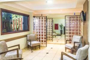 a waiting room with chairs and wine bottles at Hotel Paranoa in Jaboticabal