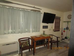 a room with a table and two chairs and a television at Bunkhouse on Bomoseen in Castleton