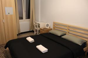 a bedroom with a bed with two towels on it at Uddin House in Genoa