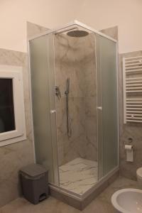 a shower with a glass door in a bathroom at Uddin House in Genoa