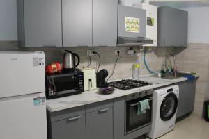 a kitchen with a stove top oven next to a microwave at Uddin House in Genoa