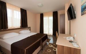 a hotel room with a bed and a desk with a phone at Hotel Villa Matić in Neum