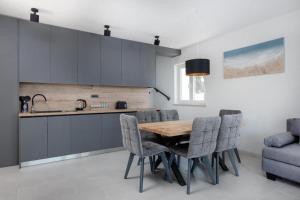 a kitchen with a wooden table and chairs at Villa Azure Bay in Povlja