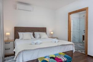 a bedroom with a large bed with towels on it at Villa Azure Bay in Povlja
