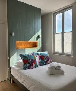 a bedroom with a bed with two towels on it at Les Bains Boyardville - Hôtel et Restaurant in Boyard-Ville