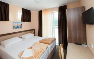 a hotel room with a bed and a television at Hotel Villa Matić in Neum