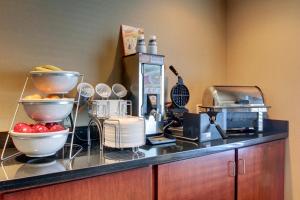 a kitchen with a counter with bowls of fruit on it at Cobblestone Inn & Suites - Harvey in Harvey