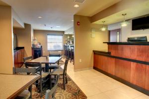 a restaurant with a bar and tables and chairs at Cobblestone Inn & Suites - Harvey in Harvey +25 photos