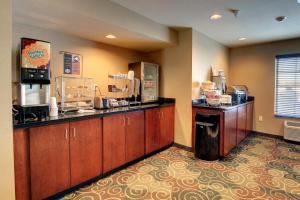 a kitchen with wooden cabinets and a counter top at Cobblestone Inn & Suites - Harvey in Harvey