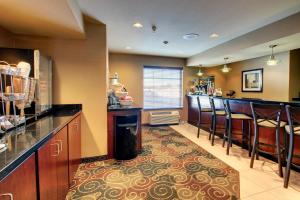 a kitchen with a bar and some stools at Cobblestone Inn & Suites - Harvey in Harvey