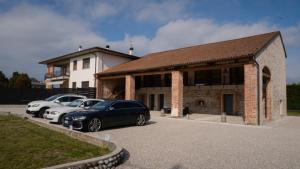 two cars parked in a parking lot in front of a building at B&B Cà Breganze in Breganze