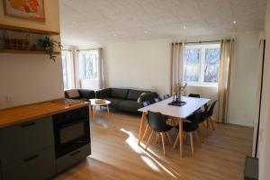 a kitchen and living room with a table and a couch at Billund Guest Lodge in Grindsted