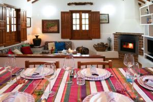 a table with glasses and plates on it with a fireplace at Casa Rural Milagrosa in Valsequillo