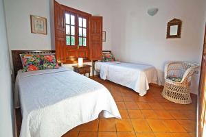 a bedroom with two beds and a chair at Casa Rural Milagrosa in Valsequillo +8 photos