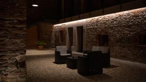 a room with chairs and a stone wall at B&B Cà Breganze in Breganze
