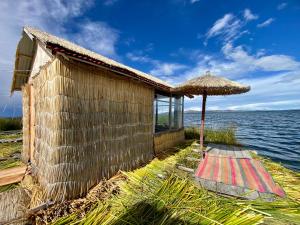 a building with an umbrella next to the water at Islas Chimu in Puno