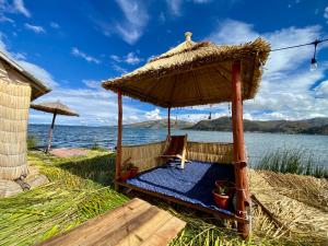 a gazebo on the beach next to the water at Islas Chimu in Puno