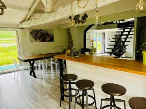 a kitchen with a bar with stools and a table at Gîte de la Galimondaine in Bouguenais
