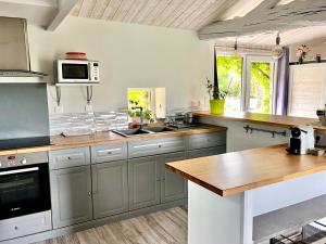 a kitchen with gray cabinets and a wooden counter top at Gîte de la Galimondaine in Bouguenais